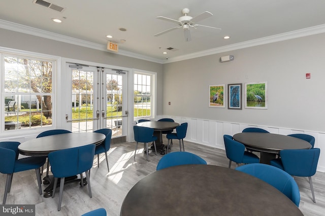 dining space featuring ceiling fan, light wood-type flooring, crown molding, and french doors