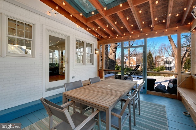 sunroom with beam ceiling, a wealth of natural light, and wooden ceiling