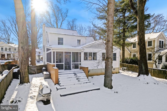 snow covered property with a sunroom