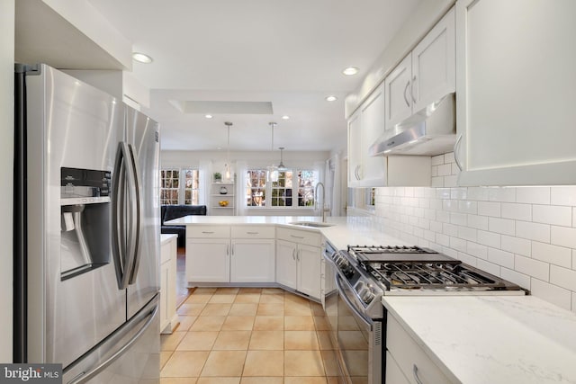 kitchen featuring sink, stainless steel appliances, kitchen peninsula, pendant lighting, and exhaust hood