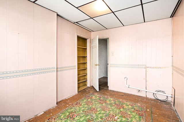 unfurnished bedroom featuring a drop ceiling