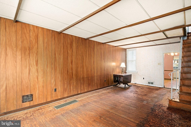 empty room featuring wooden walls and hardwood / wood-style floors