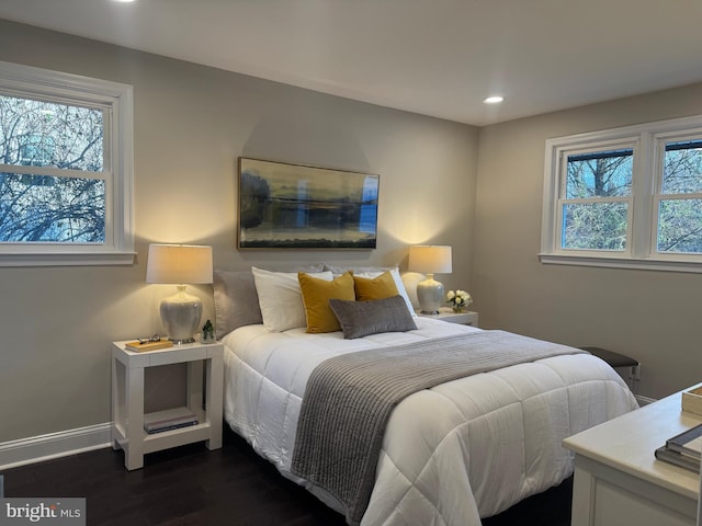 bedroom with dark hardwood / wood-style floors and multiple windows