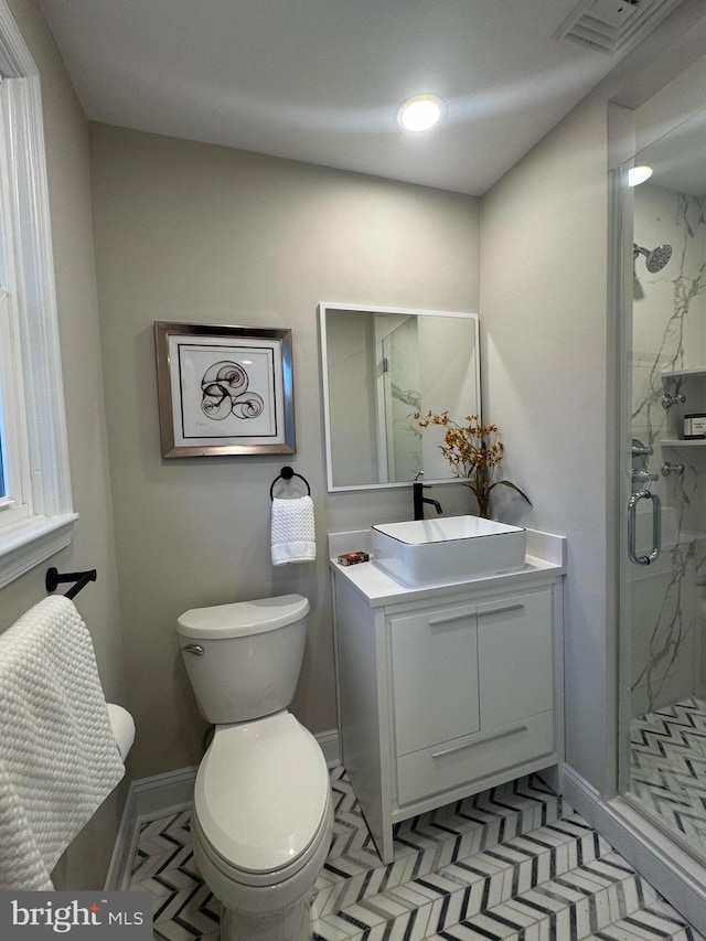 bathroom with tile patterned floors, vanity, toilet, and a shower with shower door