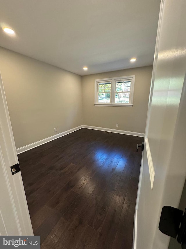 empty room with dark wood-type flooring