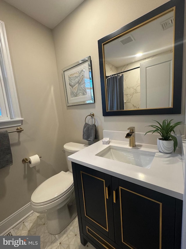 bathroom featuring toilet, vanity, and walk in shower