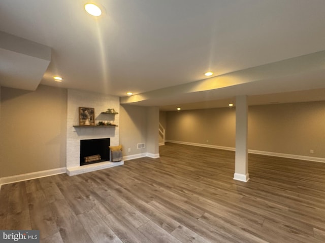 basement with hardwood / wood-style flooring and a fireplace