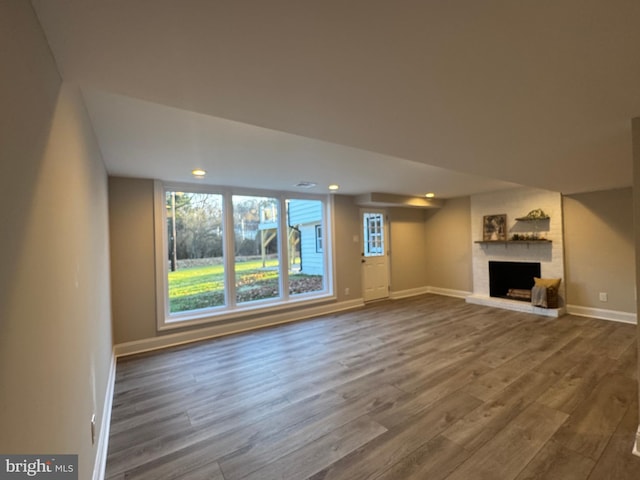 unfurnished living room featuring a fireplace and hardwood / wood-style flooring