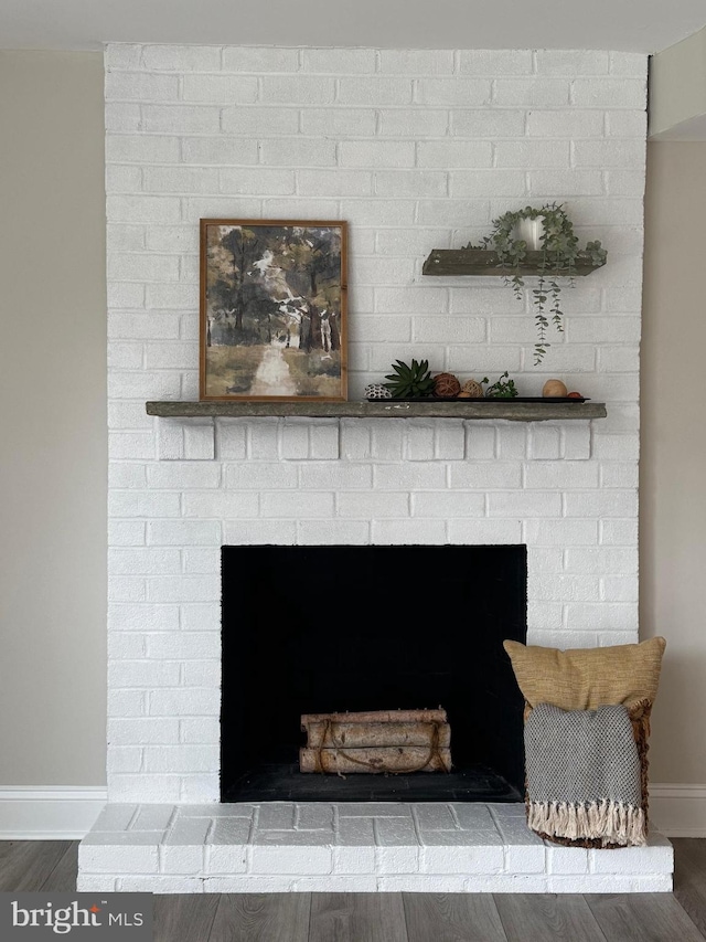 interior details with hardwood / wood-style floors and a brick fireplace