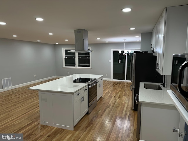 kitchen featuring hanging light fixtures, a kitchen island, island exhaust hood, stainless steel range with electric stovetop, and white cabinets