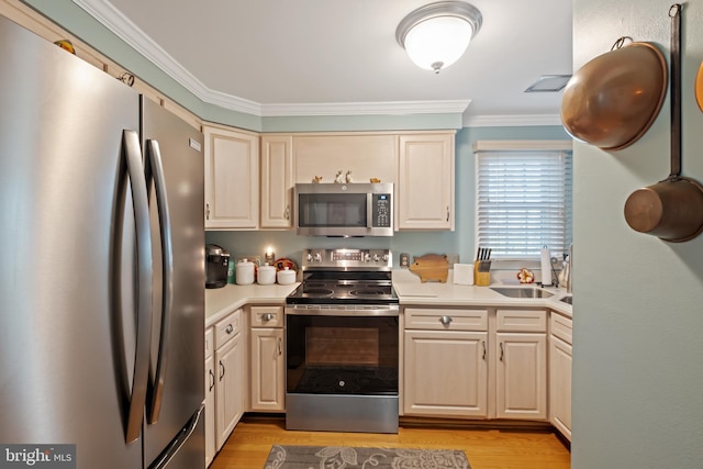 kitchen featuring sink, crown molding, light hardwood / wood-style flooring, stainless steel appliances, and cream cabinets