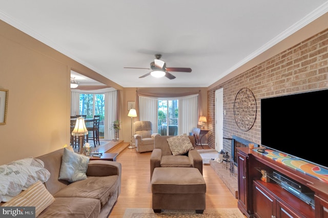 living room with crown molding, brick wall, ceiling fan, and light hardwood / wood-style floors