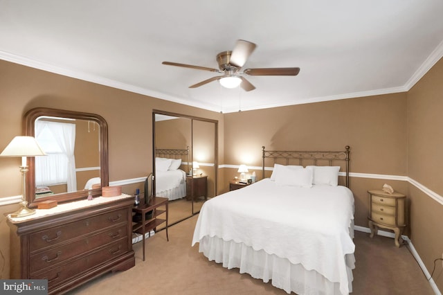 carpeted bedroom with crown molding, ceiling fan, and a closet