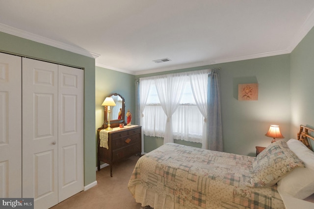 bedroom with ornamental molding, carpet flooring, and a closet