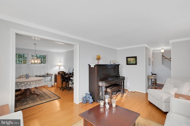 living room featuring an inviting chandelier, hardwood / wood-style floors, and ornamental molding