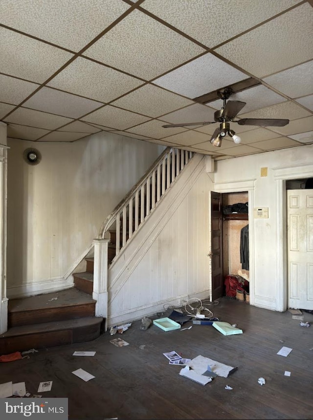 unfurnished living room featuring wood-type flooring, a paneled ceiling, and ceiling fan