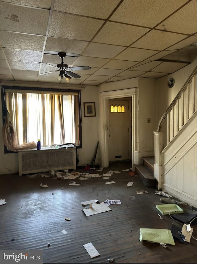 interior space featuring radiator heating unit, a paneled ceiling, dark hardwood / wood-style flooring, and ceiling fan