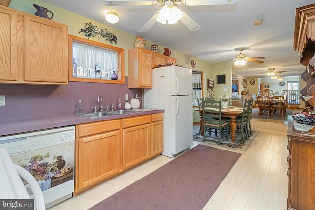 kitchen featuring white appliances, sink, light brown cabinetry, and light hardwood / wood-style flooring