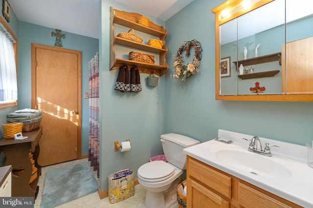 bathroom featuring tile patterned flooring, vanity, and toilet