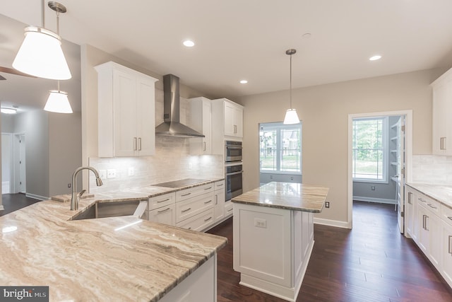 kitchen featuring white cabinets, wall chimney exhaust hood, a kitchen island, and sink