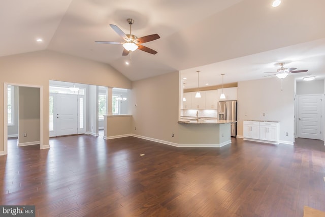 unfurnished living room featuring ceiling fan, dark wood-type flooring, and vaulted ceiling