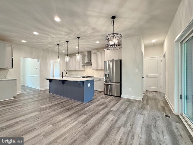 4035 Tamaron Ct, Brandywine, MD 20613 - kitchen featuring stainless steel fridge, wall chimney exhaust hood, recessed lighting, a kitchen bar, and light countertops