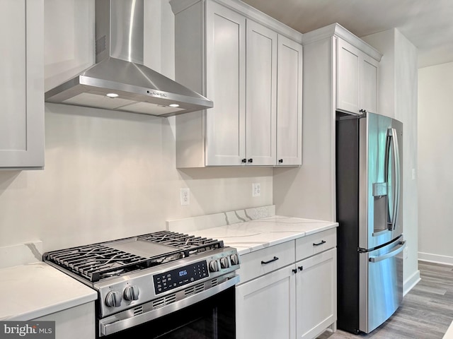 4035 Tamaron Ct, Brandywine, MD 20613 - kitchen with wall chimney exhaust hood, appliances with stainless steel finishes, light wood finished floors, white cabinets, and baseboards
