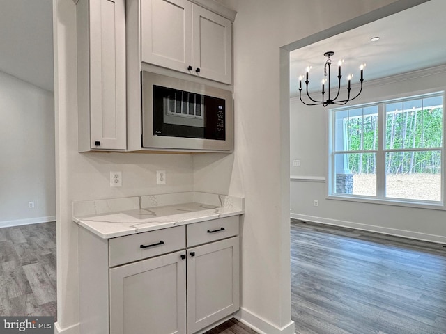 4035 Tamaron Ct, Brandywine, MD 20613 - kitchen featuring built in microwave, a chandelier, baseboards, wood finished floors, and ornamental molding