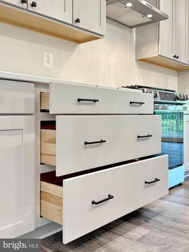 4035 Tamaron Ct, Brandywine, MD 20613 - kitchen view of wall chimney range hood, wood finished floors, and stainless steel range