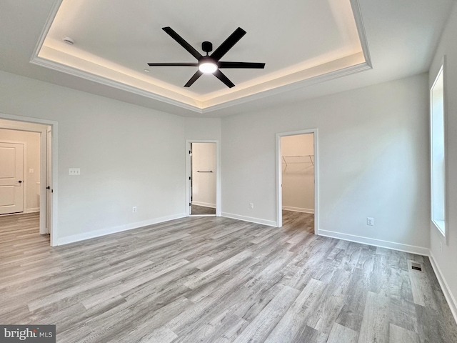 4035 Tamaron Ct, Brandywine, MD 20613 - unfurnished bedroom featuring a tray ceiling, light wood-style flooring, a spacious closet, baseboards, and a closet
