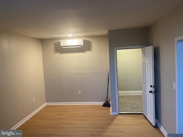 interior space with light hardwood / wood-style floors and a wall unit AC