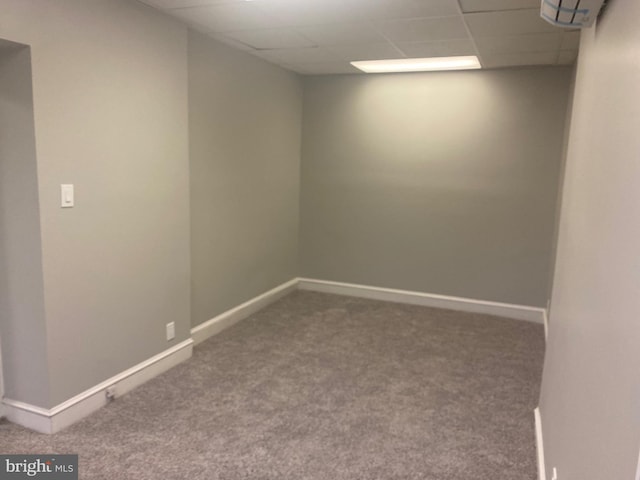 carpeted spare room with a paneled ceiling