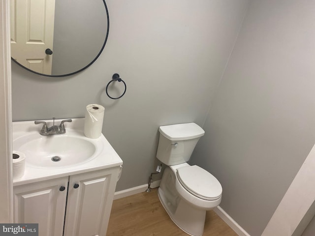 bathroom featuring vanity, hardwood / wood-style flooring, and toilet