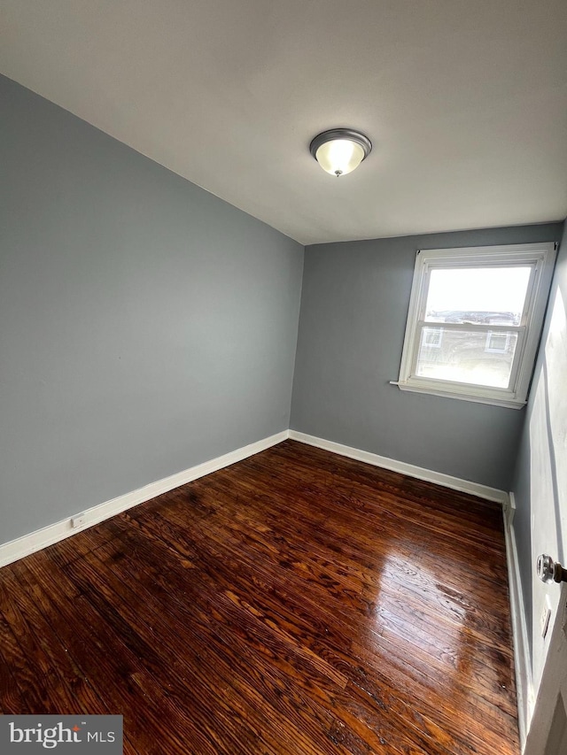 unfurnished room with dark hardwood / wood-style flooring