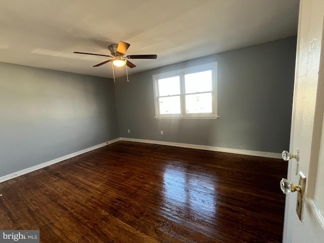 spare room featuring dark hardwood / wood-style floors and ceiling fan