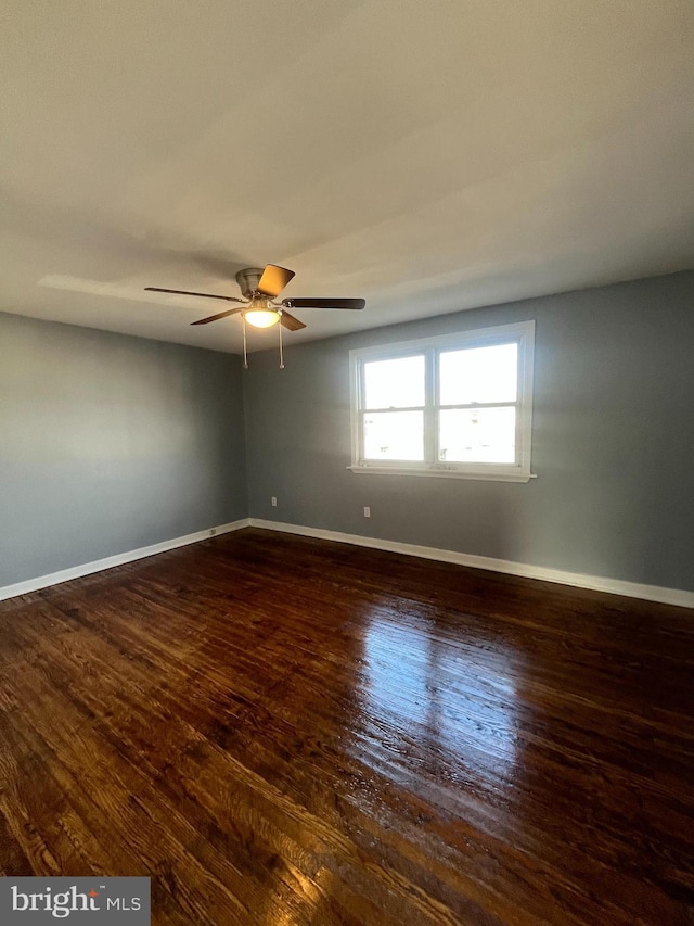 spare room with ceiling fan and dark hardwood / wood-style flooring