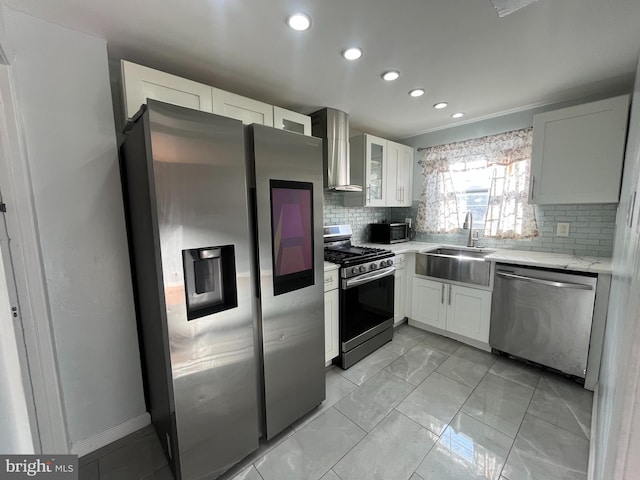 kitchen with sink, white cabinets, wall chimney range hood, and appliances with stainless steel finishes