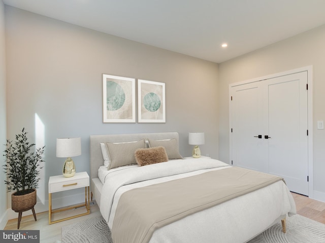 bedroom featuring light wood-type flooring and a closet