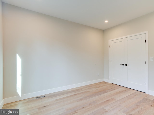 unfurnished bedroom featuring a closet and light wood-type flooring