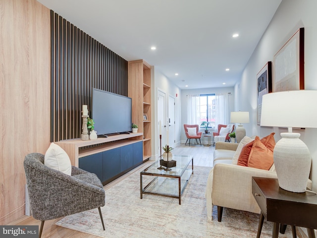 living room featuring hardwood / wood-style flooring and wood walls