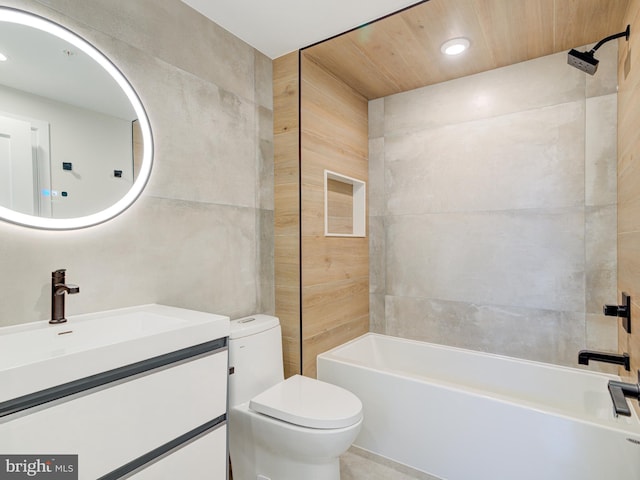 full bathroom featuring vanity,  shower combination, toilet, and tile walls