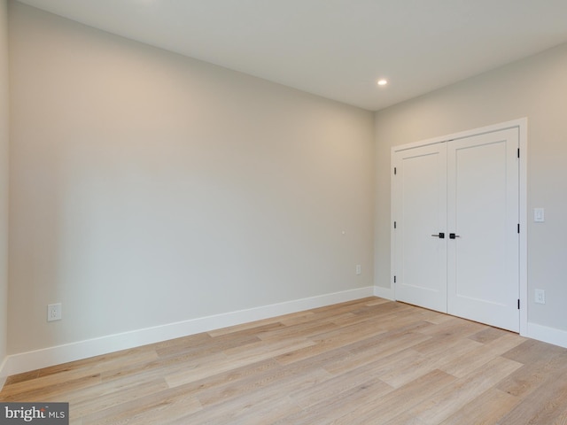 unfurnished bedroom featuring light hardwood / wood-style floors and a closet