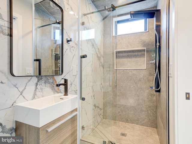 bathroom featuring vanity, decorative backsplash, a shower with shower door, and tile walls