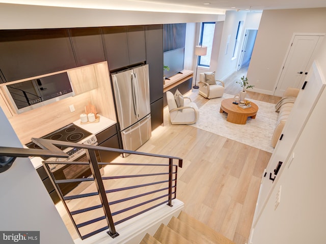 kitchen featuring stainless steel refrigerator and light hardwood / wood-style floors