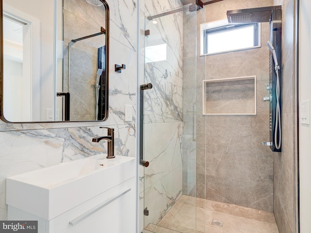 bathroom with an enclosed shower, decorative backsplash, vanity, and tile walls