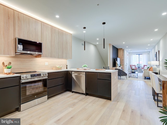 kitchen featuring light wood-type flooring, light brown cabinetry, and appliances with stainless steel finishes