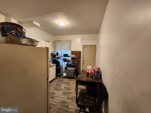 kitchen with white cabinets, white refrigerator, and hardwood / wood-style flooring