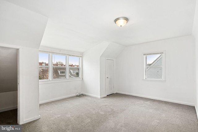 bonus room with vaulted ceiling and carpet