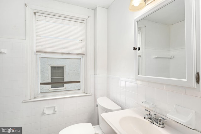 bathroom with tile walls, toilet, and vanity