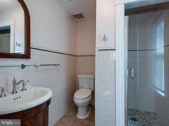 bathroom with vanity, tile patterned floors, toilet, tile walls, and an enclosed shower